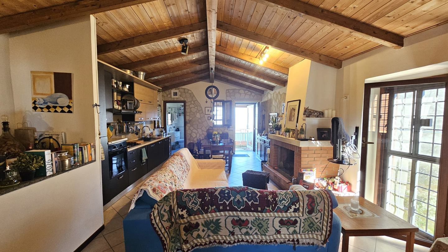 Soggiorno con angolo cottura e camino